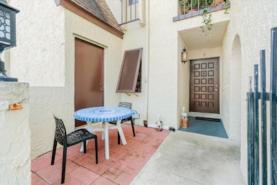 Property entrance with stucco siding and outdoor dining area