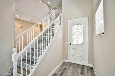 Entryway with wood finished floors, baseboards, an