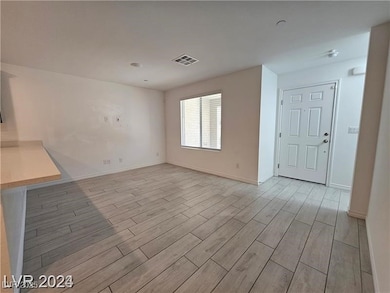 Unfurnished living room featuring wood finish floors and baseboards