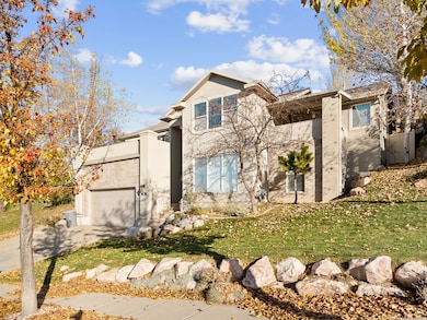 View of front of house with stucco siding, driveway, a garage, and a front yard