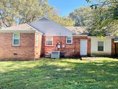 Rear view of property with a lawn and central AC u