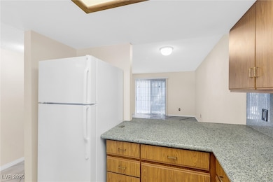 Kitchen featuring light stone countertops, wood ca