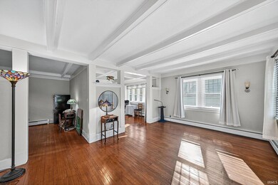Living area featuring hardwood / wood-style floors, beam ceiling.