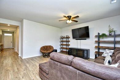 Living room featuring ceiling fan, light wood finished floors, baseboards, and recessed lighting