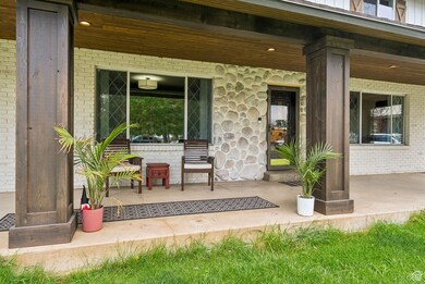 Doorway to property featuring covered porch and brick siding