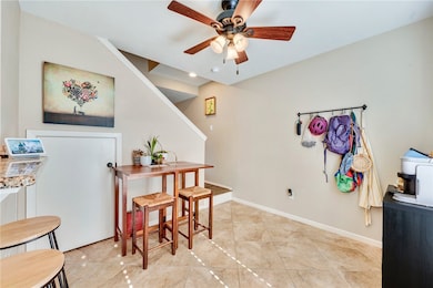 Dining room featuring a ceiling fan and baseboards