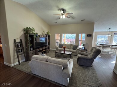 Living area featuring ceiling fan, dark wood-style
