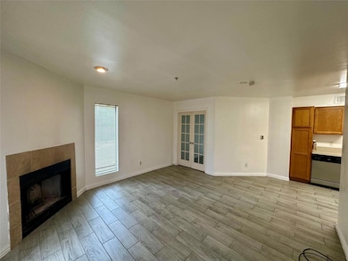 Unfurnished living room with baseboards, light woo