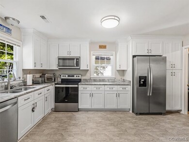 Open Kitchen with granite countertops, stainless steel appliances and newer cabinets with vinyl floors