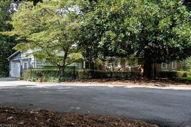 Front of home is nestled among mature Magnolia trees and features nice flat, paved driveway for parking multiple cars and for easy maneuvering.
