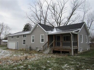Back of house with covered porch and a garage