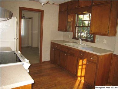 Another view of kitchen showing sink and cabinets.