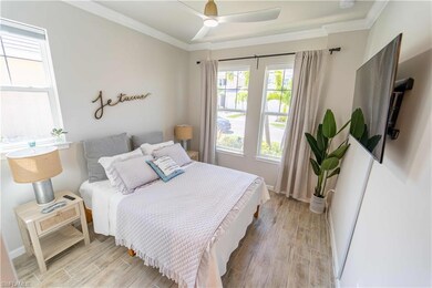Bedroom with ceiling fan, crown molding, and light