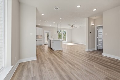 Unfurnished living room with ceiling fan, sink, an