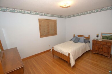 Bedroom featuring baseboards, light wood finished 