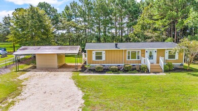 Single story home featuring a front lawn and a car