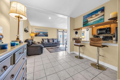 Living area with light tile patterned floors and recessed lighting