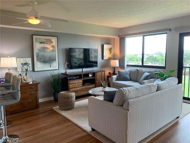 Living room featuring wood finished floors, a ceiling fan, and a textured ceiling