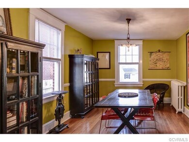 Large dining room with hardwood floors and chair rail.