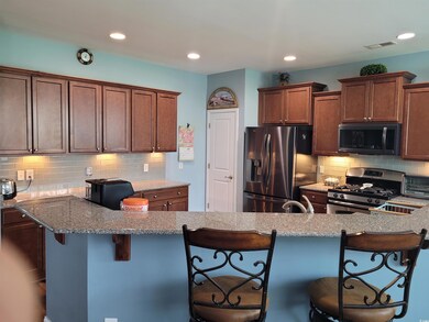 Kitchen with light stone counters, tasteful backsp