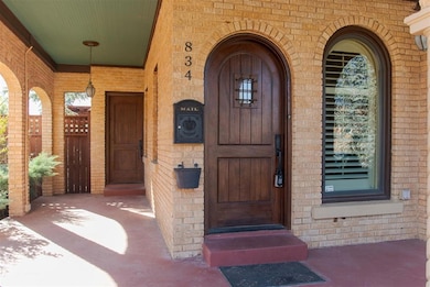 Property entrance featuring brick siding and a porch
