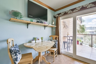 The living room is accented with soft blue walls, warm lighting, and a welcoming layout perfect for casual dining and entertaining.