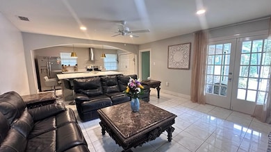 Living room featuring arched walkways, a ceiling fan, french doors, light marble finish flooring, and recessed lighting