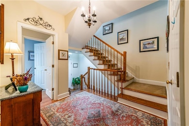 Staircase with wood finished floors and a chandelier