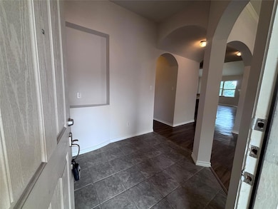 Unfurnished room featuring arched walkways