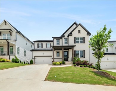 View of front of house with an attached garage, driveway, and a front lawn