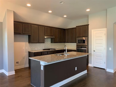 Kitchen with stainless steel appliances, dark bro