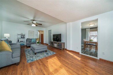 The living room with newer laminate flooring is bi