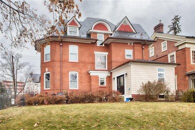 All brick home with cedar shake style vinyl siding