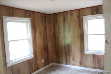 Unfurnished room featuring wood walls and a wealth of natural light