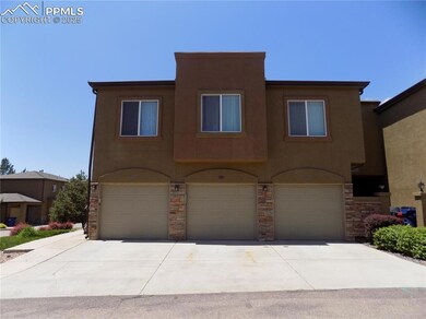View of front of home with a garage, stucco siding, driveway, and stone siding