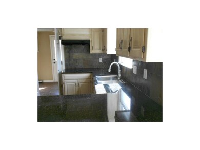 Kitchen with granite counter tops. Stainless sink.