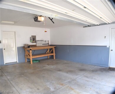 Garage featuring a workshop area and a garage door opener