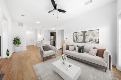 Living room featuring visible vents, ceiling fan, and light wood finished floors
