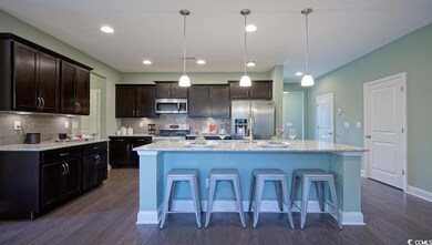 Kitchen featuring appliances with stainless steel finishes, dark wood-style flooring, tasteful backsplash, and recessed lighting