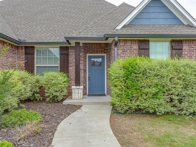 View of exterior entry featuring brick siding and roof with shingles
