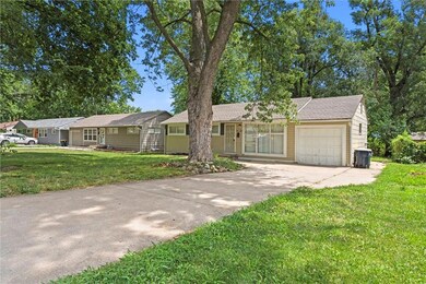 Ranch-style home featuring a garage and a front lawn