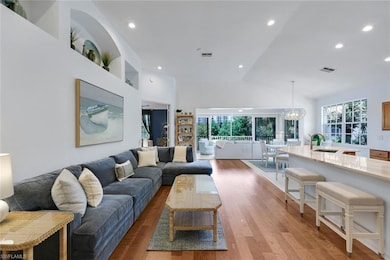 Living room featuring recessed lighting, light wood-style flooring, a 3,000 chandelier, (does not convey) and high vaulted ceiling