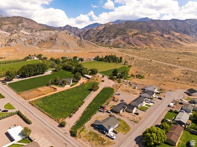 Aerial overview of property's location featuring mountains, nearby suburban area, and rural landscape