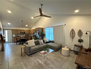 Living room featuring light tile patterned floors, a ceiling fan, recessed lighting, and high vaulted ceiling
