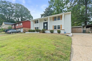 Split foyer home featuring brick siding, a porch, and driveway
