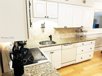 Kitchen with dishwasher, light stone countertops,