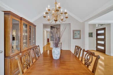 Dining area with light wood-style floors, a chand