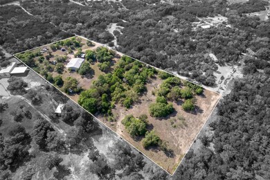 Birds eye view of property with a wooded view