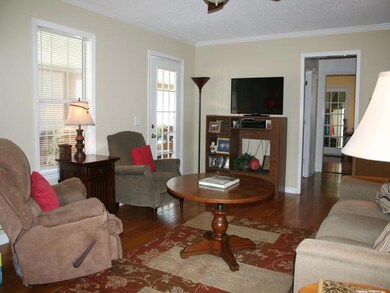 Separate 19x13 den, hardwood floors, portable gas fireplace stays, door to left leads to sunroom, door to right is entrance to hall and kitchen.