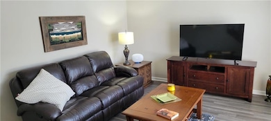 Living area with wood finished floors and baseboards